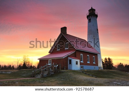 Beautiful sunrise at Tawas Point Lighthouse, East Tawas, Michigan. USA Just a dusting of snow on the ground in this Michigan Winter scene.