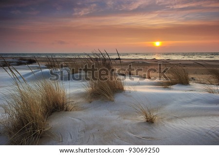 Beautiful Lake Huron Sunrise, Tawas Point State Park, Michigan USA Snow and ice mix with the drifting sand making this a pretty winter scene.