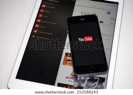 Samara, Russia - February 17, 2015: YouTube app open in the mobile phone Iphone 5s and ipad air2. Apple Corporation main direction rapidly developing market of smartphones.