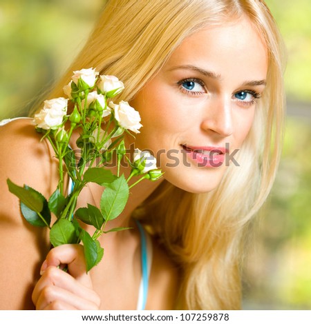 Young happy smiling cheerful woman with bouquet of white roses