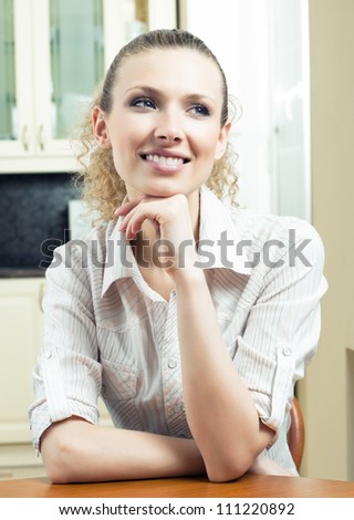 Portrait of young smiling beautiful blond woman thinking, indoors