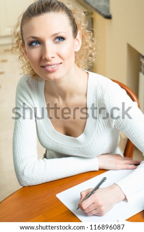 Young beautiful blond woman studying with notebook or organiser, indoors