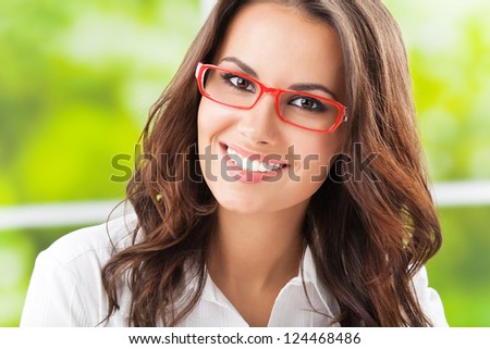Portrait of young happy smiling cheerful business woman in glasses, at office