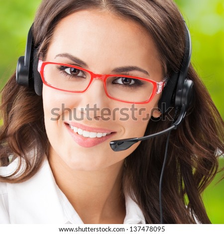 Portrait of happy smiling cheerful beautiful young support phone operator in headset, at office