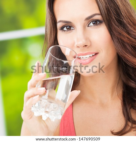 Portrait of young woman drinking water, outdoor
