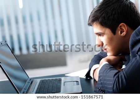 Portrait of successful happy smiling business man working with laptop at office, with copyspace