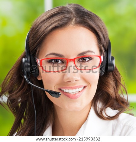 Portrait of happy young support phone operator in headset, at office
