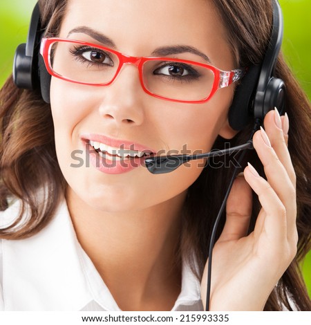 Portrait of happy young support phone operator in headset, at office