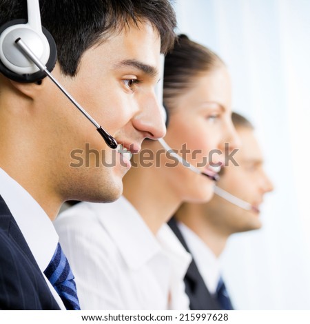Three happy customer support phone operators, at workplace
