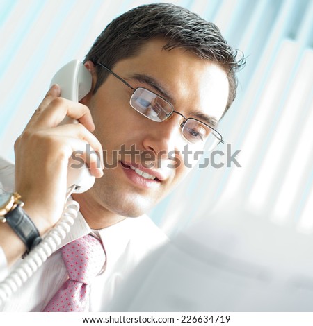Businessman with phone and document at office