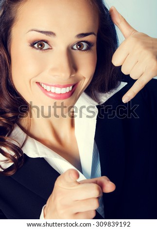Young happy smiling brunette businesswoman with call me gesture