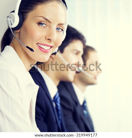 Three smiling young customer support phone operators at workplace, customer service concept