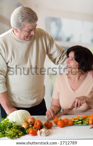 Elderly happy couple cooking at kitchen