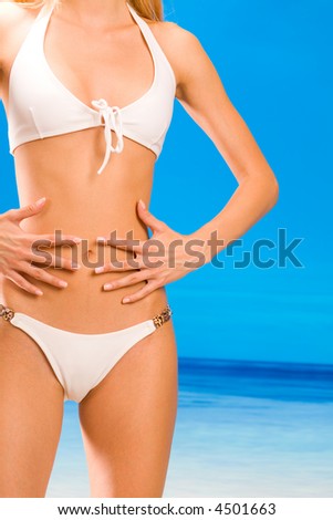 Torso of young sexual beautiful tanned woman in bikini on the beach