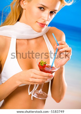 Young beautiful blond woman with cocktail on tropical sea beach
