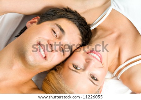 Portrait of young happy amorous couple at bedroom