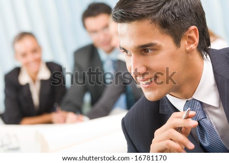 Portrait of successful businessman and business team at office meeting