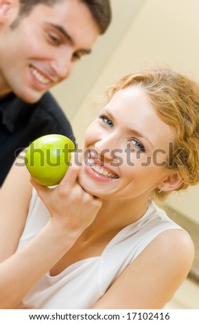 Portrait of young amorous couple with apple at home