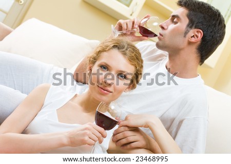 Young couple celebrating with red wine at home