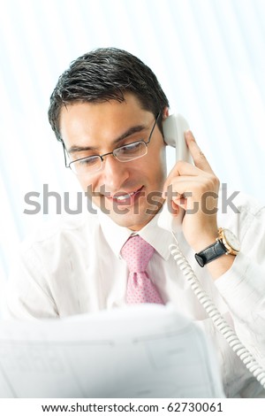 Businessman with phone and document at office