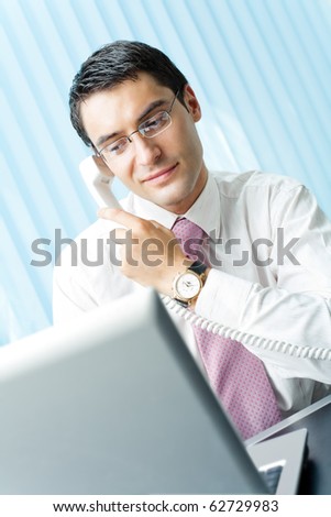 Businessman with phone and laptop at office