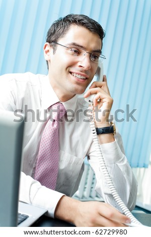 Businessman with phone and laptop at office