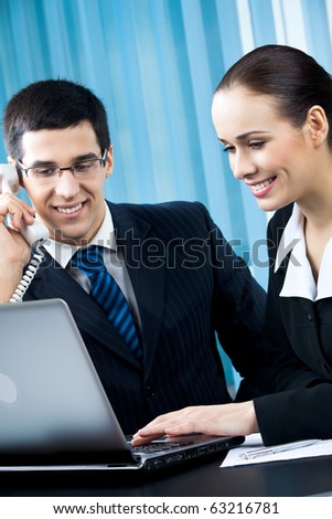 Two happy businesspeople working together at office
