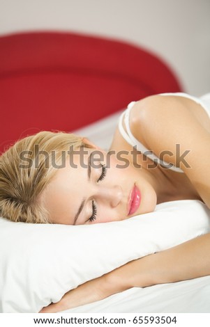 Young attractive blond woman sleeping on bed
