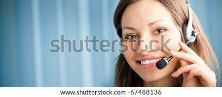 Portrait of happy smiling support phone operator in headset at workplace. You can use left part for slogan, big text or banner.