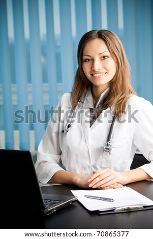 Portrai of happy smiling female young doctor with laptop at office