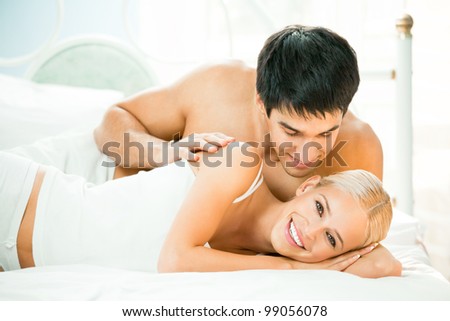 Young beautiful couple making love in bed