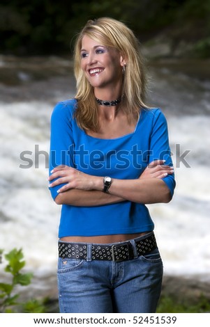 A blonde model outdoors near a waterfall