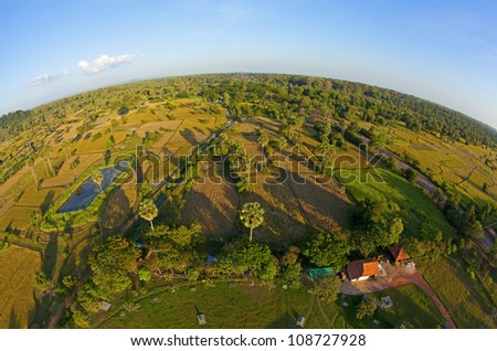 Fisheye aerial view of Cambodian countryside with Angkor Wat near horizon