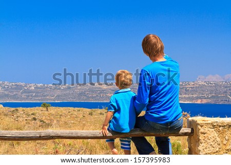 back view of father and son looking at the sea