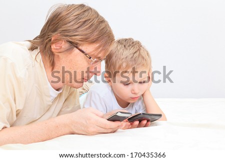 father and son with mobile phones at home, family communication