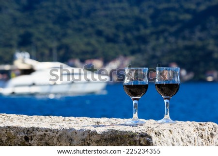 Two glasses of red wine against the sea, summer vacation