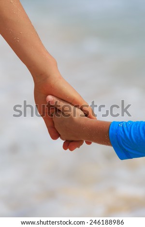 mother and son holding hands on sea vacation