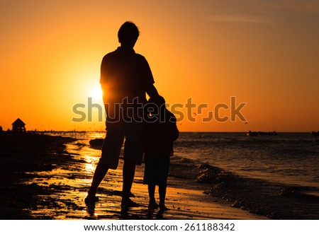 father and son hug at sunset beach