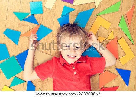 happy little boy with puzzle toys on wooden floor, early learning