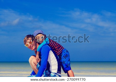 father and little son hug on summer beach, family lifestyle