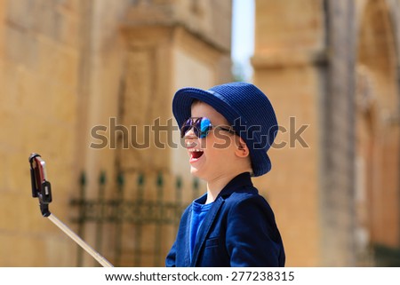 smart happy little boy taking selfie stick picture while travel in Europe, Malta