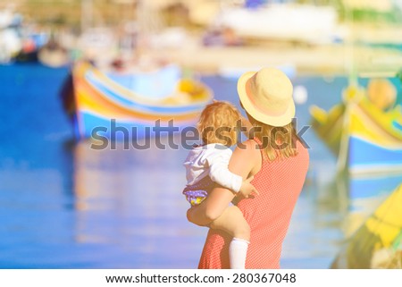 mother and little daughter looking at traditional boats in Malta, family travel