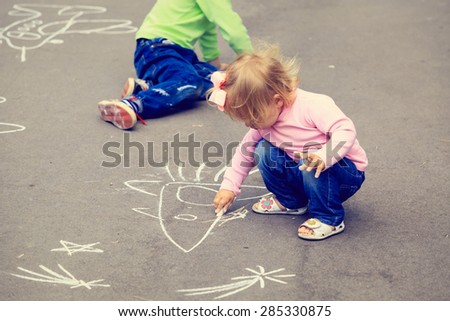 little boy and toddler girl drawing rocket on asphalt, kids outdoor activities