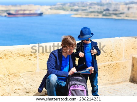 father and little son looking at map, family travel in Europe