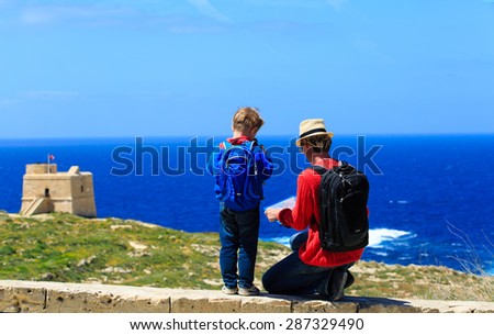 father and little son looking at map, family travel