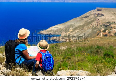 mother and son looking at map in mountains, family travel