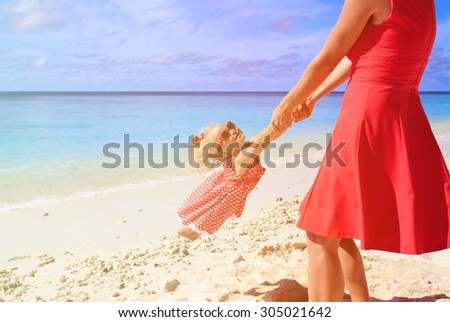 mother and daughter playing on summer tropical beach