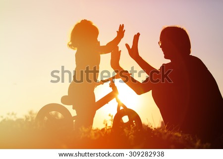 father and daughter having fun riding bike at sunset, active kids sport