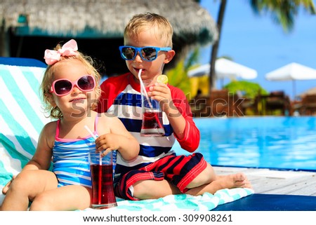 kids relax on tropical beach resort and drink juices, family vacation