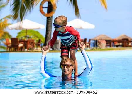 father and son having fun in swimming pool, family vacation